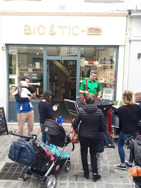 Devant une boutique, des familles entourent Rigadin
