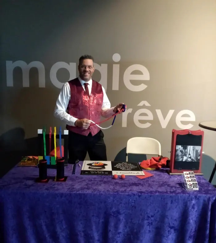 Rigadin derrière une table de magie couverte d’un velours violet